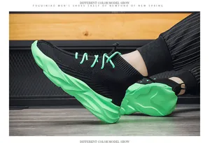 Detail view of high-top breathable sock sneakers in black with neon green wavy soles.