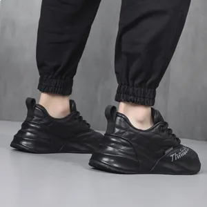 Vista laterale di eleganti sneaker nere in vera pelle da uomo indossate da un modello