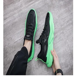 Dettaglio ravvicinato di scarpe da ginnastica traspiranti in mesh nero con suole verdi neon