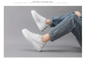 Zijaanzicht van witte leren platform sneakers voor heren met distressed jeans.