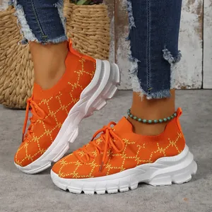 Close-up of breathable orange knit platform sneakers with stylish pattern