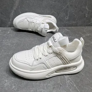 Detailweergave van witte leren herensneakers met een dikke zool met luchtkussen.