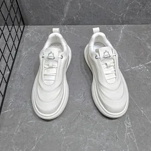 Detail view of stylish men's white chunky sneakers with leather finish and thick soles.