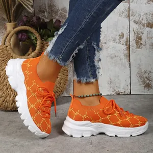 Close-up detail of women's orange knitted platform sneakers for casual travel style
