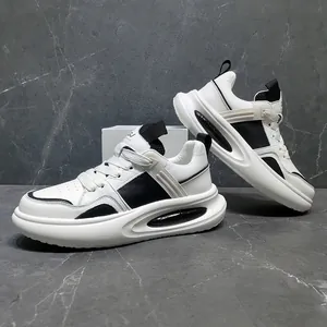 Detail van heren sneakers van wit en zwart leer met dikke plateauzolen en verhoogde hak
