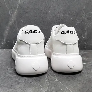 Detailweergave van witte lederen platform sneakers met reliëf klaverpatroon op de hiel.