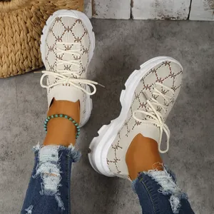 Close-up view of stylish women's beige breathable platform sneakers with knitted monogram pattern