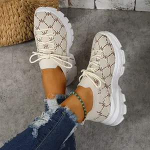 Detailed view of women's beige knit sneakers with chunky white platform soles and laces