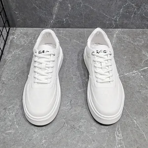 Detailweergave van witte sneakers met dikke zool, hoogwaardig leer en vetersluiting.
