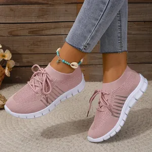 Detail of pink flying knit mesh sneakers with white sole and lace-up design