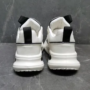 Achteraanzicht van witte dad shoes met dikke zolen, leertextuur en zwarte treklipjes.