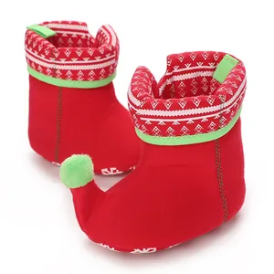 Detailed view of red Christmas-themed baby snow boots with festive snowflake patterns.