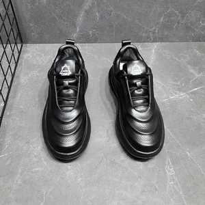 Top-down detail of black leather men's sneakers featuring textured wavy wave patterns