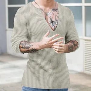 Close-up detail of men's slim fit deep V-neck long sleeve ribbed knit shirt in beige