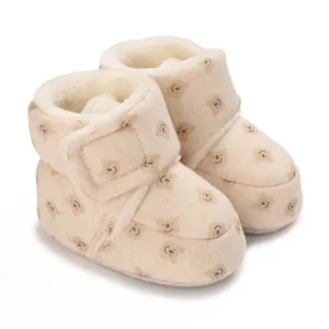Detalle de acogedoras botas de invierno para bebé en color beige con estampado de osos