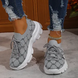 Detailed shot of women's grey platform sneakers with stylish pattern and white soles.
