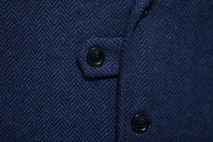 Dettaglio del tessuto in tweed spigato blu scuro del gilet e dei bottoni neri eleganti