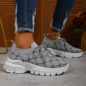 Close-up of women's grey breathable knit sneakers with thick white soles and geometric patterns.