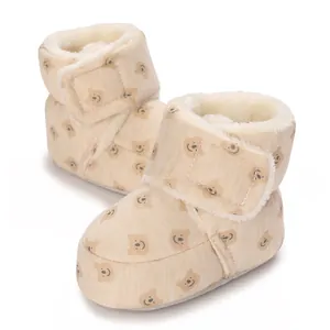 Detalle de botas de invierno para bebé con forro polar y estampado de ositos.