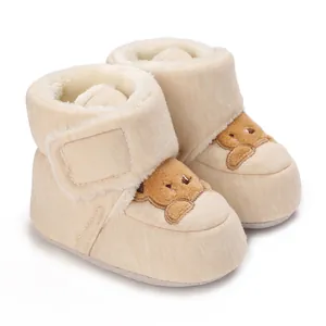 Botines de bebé color crema con suela blanda, forro polar cálido y diseño de osito