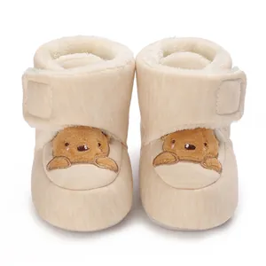 Primer plano de zapatos de invierno para bebé con osito y forro de felpa