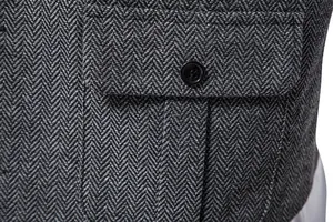 Dettaglio del tessuto in tweed grigio spigato e della tasca di un gilet da uomo