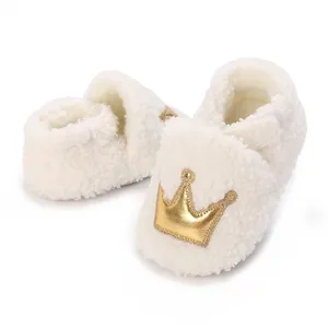 Detail of soft fleece baby booties with golden crown embroidery for newborn warmth