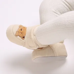 Primer plano de patucos de invierno para bebé con osito y suela blanda