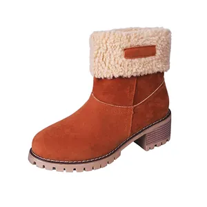 Gros plan de bottes de neige en daim marron avec revers en fausse fourrure et talon épais