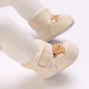 Detalle de zapatos de bebé con forro de felpa y bordado de oso para caminar suave