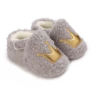 Close-up of warm grey plush baby shoes featuring a gold crown applique for winter