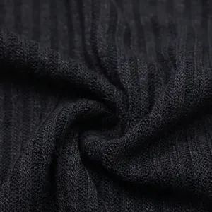 Macro detail shot showing the soft texture of black ribbed knit fabric for sweaters