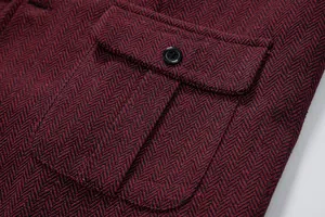 Dettaglio macro che mostra la tasca e il bottone di un gilet da abito in tweed bordeaux.