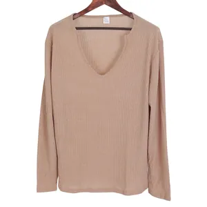 Detail view of men's ribbed knit long sleeve shirt with deep V-neck in light brown.