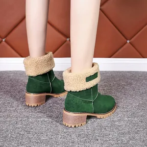 Détail de bottines en daim vert avec bordure en fausse fourrure beige et talon épais