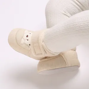 Detalle de botas de invierno beige para bebé con diseño de oso y suelas blandas antideslizantes