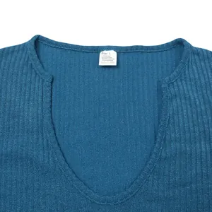 Close-up detail of the v-neckline and inner fabric label on a men's blue knitted t-shirt