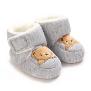 Close-up of warm grey baby winter boots with cute cartoon bear embroidery and fleece lining.