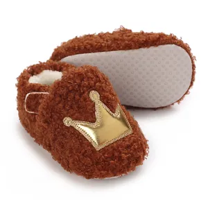 Cozy brown fuzzy baby booties with golden crown detail and soft non-slip sole.