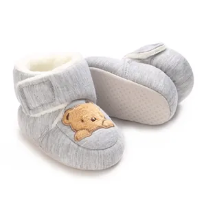 Detail of grey baby walking booties with warm fleece lining and bear patch