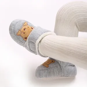 Close-up of winter baby fleece-lined warm pre-walker shoes with cute bear embroidery
