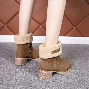 Détail de bottes de neige élégantes en daim marron avec revers en fourrure et talons