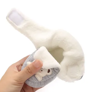 Close-up of warm white fleece lining and velcro strap on grey baby shoe.