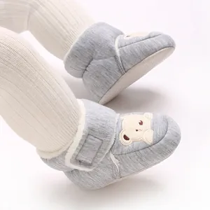 Close-up view of gray baby winter boots with cute bear embroidery and warm fleece lining.