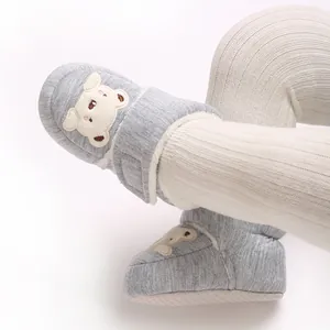 Close-up of cute cartoon bear baby winter walker shoes with warm fleece lining.