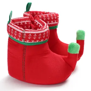 Detail view of red and green Christmas elf baby shoes made of soft warm plush fabric