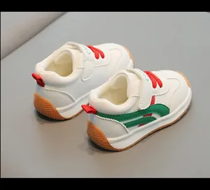Vista posteriore di scarpe da ginnastica bianche per bambini con lacci rossi.