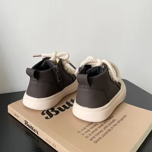 Detailed view of dark brown high-top baby walker shoes with cream rope laces