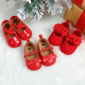 Three styles of red baby princess shoes displayed in a festive snowy Christmas scene