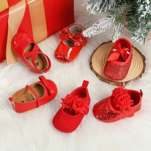 Variety of red Christmas baby princess shoes with bows and sequins on fur background